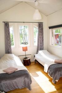two beds in a room with two windows at Husky Lodge Hostel in Kiruna