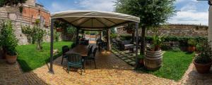 a table and chairs under an umbrella in a garden at Due Torri in San Severino Marche