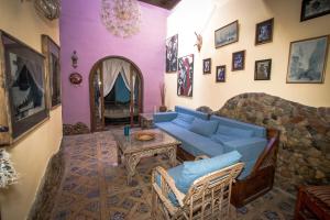 a living room with a blue couch and a stone wall at Villa Boheme & Atelier Boheme in Dahab
