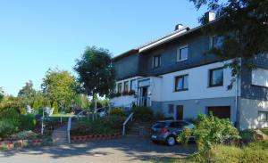 ein Haus mit einem davor geparkt in der Unterkunft Pension Hubertus in Winterberg