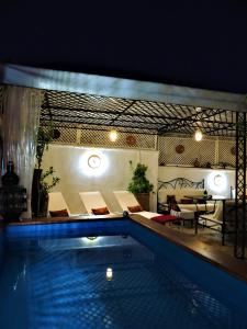 uma casa com piscina com mesa e cadeiras em Riad Tizgui Celine em Marraquexe