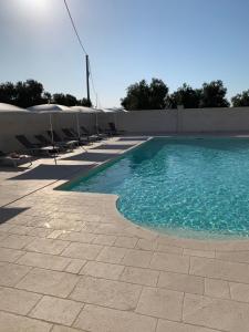 a swimming pool with chairs next to a fence at Le Terrazze Miramare B&B in Torre Canne