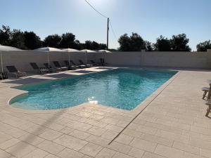 a swimming pool with chairs and a wall at Le Terrazze Miramare B&B in Torre Canne