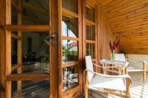 a wooden porch with two chairs and a table at Villa Pod Koniem in Kazimierz Dolny