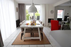 a living room with a white table and a red chair at Vakantievilla Markant in Balk +22 photos