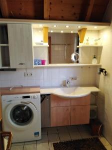 eine Küche mit einer Waschmaschine und einem Waschbecken in der Unterkunft Ferienhaus Anna in Dorum Neufeld