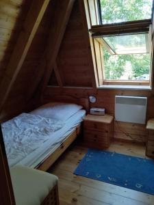 ein Schlafzimmer in einem Blockhaus mit einem Bett und einem Fenster in der Unterkunft Ferienhaus Anna in Dorum Neufeld