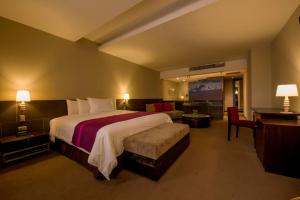 a hotel room with a large bed and a couch at Arawi Miraflores Prime in Lima