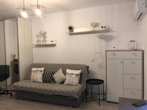 uma sala de estar com um sofá com almofadas em Cozy Place 47-Self check in & out-HBO MAX em Piteşti