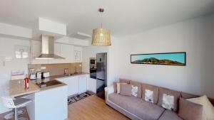 Suite Wagner في سانتا كروث دي تينيريفه: مطبخ وغرفة معيشة مع أريكة في غرفة