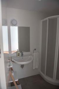 y baño blanco con lavabo y ducha. en TRIPLEX CENTRO HISTORICO 2, en Jaén