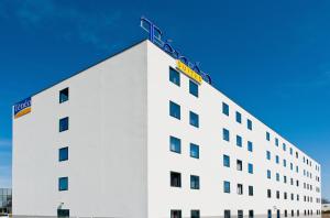 a white building with a ladder on top of it at Ténéo Apparthotel Bordeaux Mérignac Aéroport in Mérignac