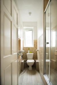 a bathroom with a toilet and a sink and a window at Central London Maida Vale 4 or 5 bed spacious apartment in London