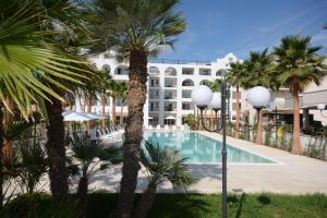 un resort con piscina e palme di Residence La Villa a Tortoreto