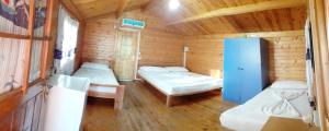 a room with two beds in a wooden cabin at TONEDA Seaside Bungalows in Dhërmi