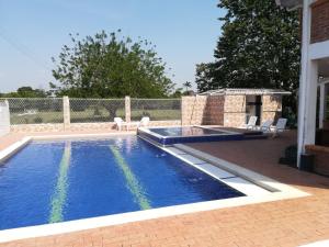 a swimming pool in a yard next to a house at Finca Campestre El Encanto in Villavicencio