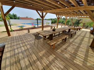 a wooden deck with a picnic table and a pool at CASA Claudina, Confort et tranquillité in Loulé