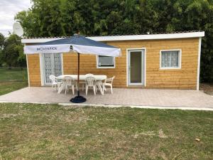 - une table de pique-nique avec un parasol en face d'une maison dans l'établissement Chez Roger et Danielle, à Salles-dʼAngles