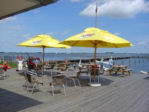a group of tables and yellow umbrellas on a pier at Vakantievilla Markant in Balk