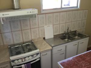 a kitchen with a stove and a sink at Cabaña en Metrenco in Temuco