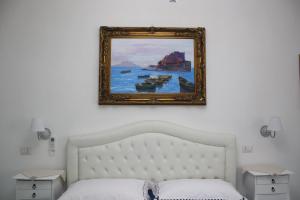 un cuadro sobre una cama en un dormitorio en IL BORGO di Iaconti, en Vietri