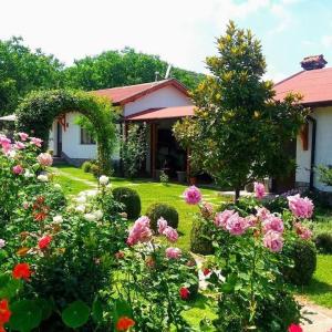 a garden with flowers in front of a house at Guest House Raiski Kаt in Mezek