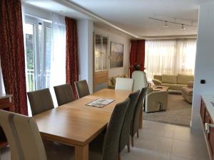 a dining room and living room with a wooden table and chairs at Sonnenhaus in Sindelfingen