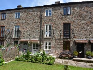 St Etheldreda's Cottage, Wells, Somerset في ويلْزْ: مبنى من الطوب كبير وامامه حديقة