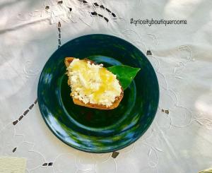 un plato verde con un trozo de pan en una mesa en Q-riosity boutique rooms en Quartu SantʼElena