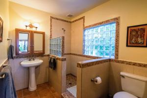 a bathroom with a sink and a toilet and a window at The Casita at The Boquete Hacienda in Boquete