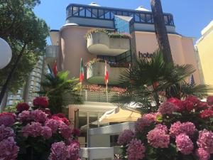 a building with flowers in front of it at Hotel Conca Verde in Lignano Sabbiadoro