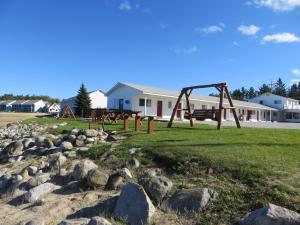 a park with a swing set and rocks at Bells Melody Motel in Mackinaw City
