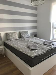 1 cama en un dormitorio con una pared a rayas en Bastion Gdański en Gdansk