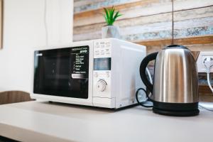 a microwave sitting on a counter next to a tea kettle at "Green Oasis Apartment" in Lviv