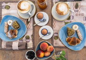 un tavolo con piatti per la colazione e tazze di caffè di Kepos Etna Relais & Exclusive Spa a Santa Venerina