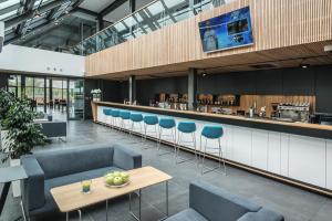 a restaurant with blue chairs and a bar at Regatta Hotel Restauracja Spa in Poznań