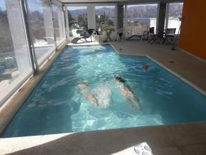 a person swimming in a large swimming pool at Refugio Playa Perelli in Villa Carlos Paz