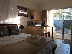 a bedroom with a bed and a table and a kitchen at Bergsig 2A in Clanwilliam