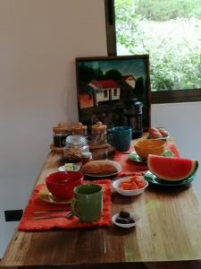 una mesa con tazones y platos de comida. en Aves de Tierras Altas, en Bijagua