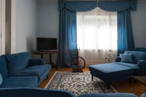 - un salon avec des canapés bleus et une fenêtre dans l'établissement Vintage Villa Magnolia, à Pula