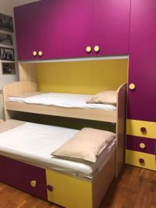 Cette chambre comprend 2 lits superposés avec des placards violets. dans l'établissement Casa Di Lia, à Pouzzoles