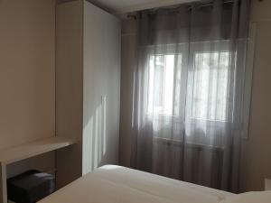 sypialnia z łóżkiem i oknem w obiekcie APARTAMENTOS PORTA NOVA w mieście Lugo