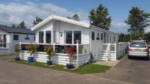 a white tiny house parked in a parking lot at Kent Getaways in Westgate on Sea