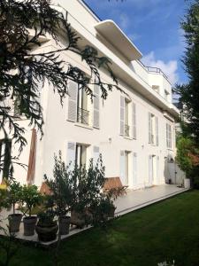 Una vista exterior de un edificio blanco con un patio. en Exceptionnel, 130 m2, vue aérienne sur Paris, en Ville-dʼAvray