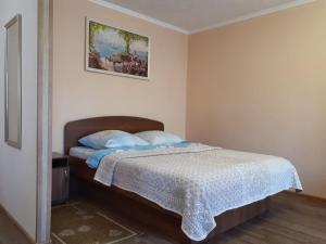 - une chambre avec un lit et des oreillers bleus dans l'établissement Lux Apartment on Potanina 19, à Öskemen
