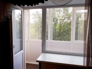 um quarto com duas janelas grandes e um balcão branco em Lux Apartment on Potanina 19 em Öskemen
