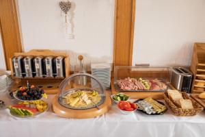 una tabella ricoperta con diversi tipi di alimenti su una tavola di Hotel-Restaurant Straussen a Harburg