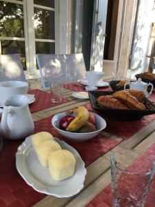 einen Tisch mit einem Teller Brot und Obst darauf in der Unterkunft Tilleuls et Bambous in Saint-Sauveur-dʼAunis