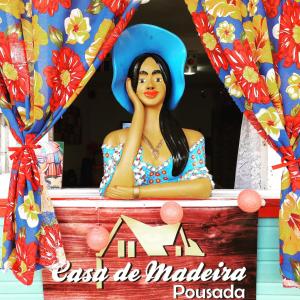 Una statua di una donna seduta sopra una casa di Pousada Casa de Madeira a Porto De Galinhas Altre 25 foto
