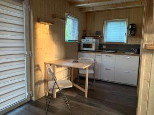 eine kleine Küche mit einem Tisch in einem winzigen Haus in der Unterkunft Cube Nature in Bitche